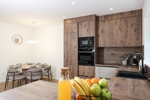 Eine moderne Küche mit Holzausstattung, einer integrierten Mikrowelle und einem Spülbecken.