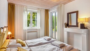 Ein Hotelzimmer mit zwei Betten, einem Kamin, einem Spiegel und einem Fenster mit Vorhängen.