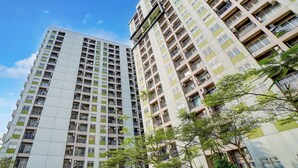 Un edificio residencial alto con varios balcones y unidades de aire acondicionado.