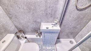 Un bany amb vàter, rentapès i plat de dutxa.