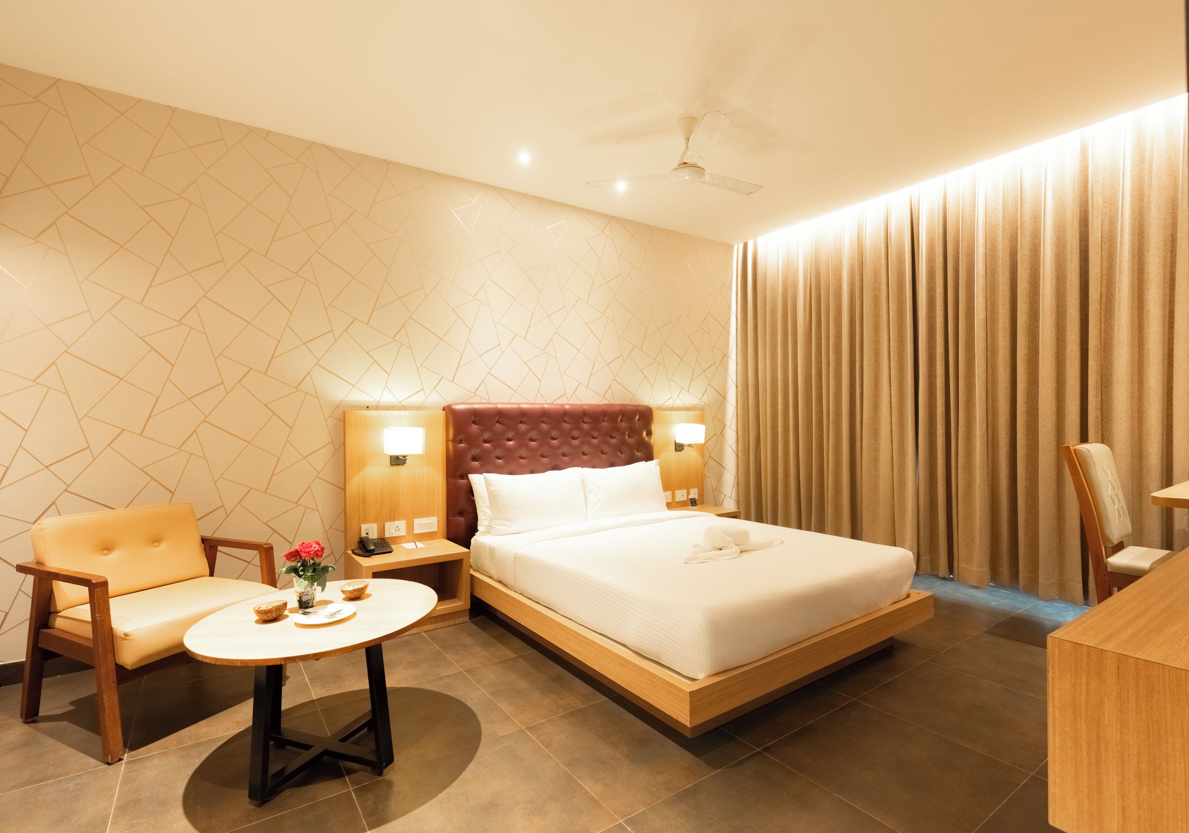 Una habitación de hotel con una cama, un sofá, una mesa y una silla.