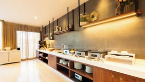 A modern kitchen with a long counter, built-in shelves, and a variety of appliances.