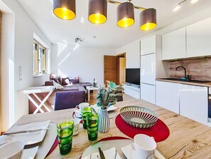 Eine moderne Küche mit weißen Schränken, einer Holz Arbeitsplatte und einem eingebauten Herd.