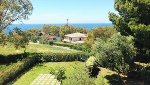 A coastal property with a view of the sea, a garden with a paved area, and a building with a tiled roof. - Residence La Giungla (Falerna)