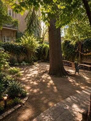 A tree-lined courtyard with a bench and a paved walkway. - Panoramic View Apartment with Piano. Vintage Style (tbilisi)