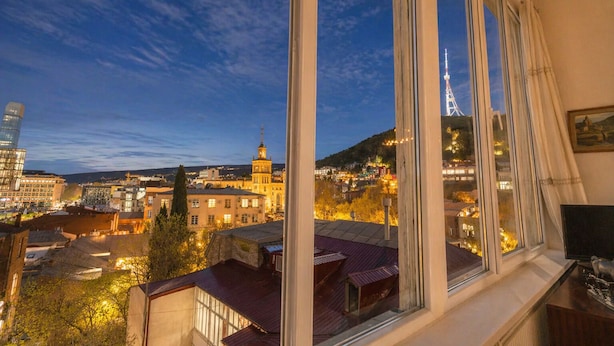 Blick auf eine Stadtansicht aus einem Fenster, einschließlich eines markanten Turms und einer Kuppelkonstruktion.