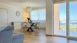 En modern lägenhet med ett matområde, en soffa, en klocka och en balkong med utsikt.