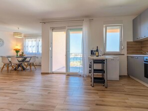 Eine moderne Wohnung mit Essbereich, Küche und Balkon.