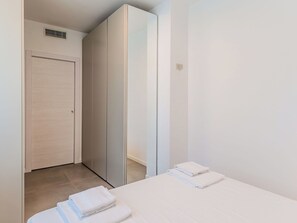 Ein Hotelzimmer mit Bett, Kleiderschrank und Badezimmertür.