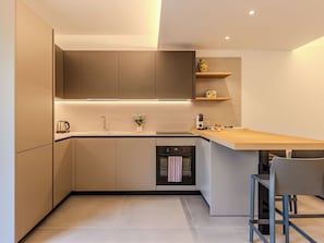 Eine moderne Küche mit eingebautem Ofen, einer Spüle und einer Arbeitsplatte.