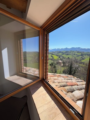 A room with a large window overlooking a mountainous landscape. - Casa Anima luxury getaway in Gualdo Macerata, Le Marche (Marche)