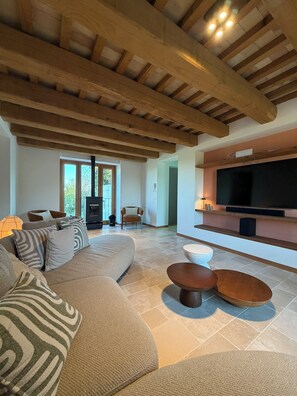 A modern living room with a large sofa, a TV, and a fireplace. - Casa Anima luxury getaway in Gualdo Macerata, Le Marche (Marche)