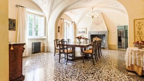 Comedor con suelo de mosaico, chimenea y candelabro.