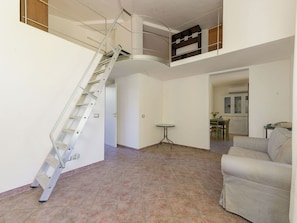Ein großzügiger Wohnbereich mit Treppe, Esstisch und einer Couch.