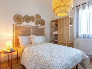 Ein Schlafzimmer mit Bett, Nachttisch, Lampe und einem Holzschrank.