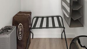 A neatly organized room with a bed, a small table, a storage unit, and a shelf. - Exquisite 1BR 30 min to FIFA (Bayonne)