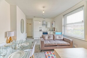 A compact living space with a kitchenette, dining area, and a sofa. - Fairhaven View by Guestz (Lytham-St-Annes)