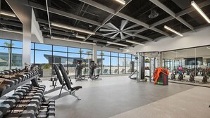 A gym with weightlifting equipment, treadmills, and exercise machines.