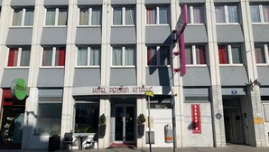 Ein Hotel mit moderner Fassade, einem gut sichtbaren Eingang und einem Schild, das es als Pension kennzeichnet.