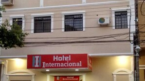 Un edificio con un letrero que dice 'Hotel Internacional' y una camioneta plateada estacionada.