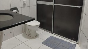 Un baño con inodoro, lavabo y cabina de ducha.