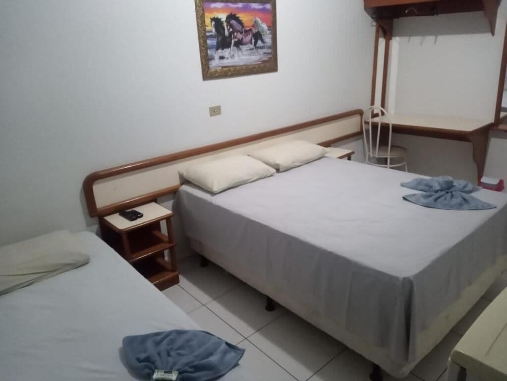 A bedroom with a bed, bedside table, and a chair.