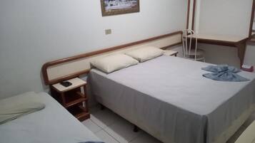 A bedroom with a bed, bedside table, and a chair.