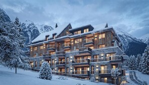 Eine mehrstöckige Lodge mit Balkonen, Holzfassade und Steindekoration, umgeben von schneebedeckten Bergen.