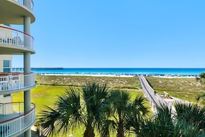 Ein Hotel direkt am Strand mit Blick auf das Meer, einen Steg und Palmen.