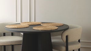 A round table with woven placemats, a black pedestal base, and two chairs with a textured fabric seat. - RentPlanet - Apartament Wałowa (Warsaw)