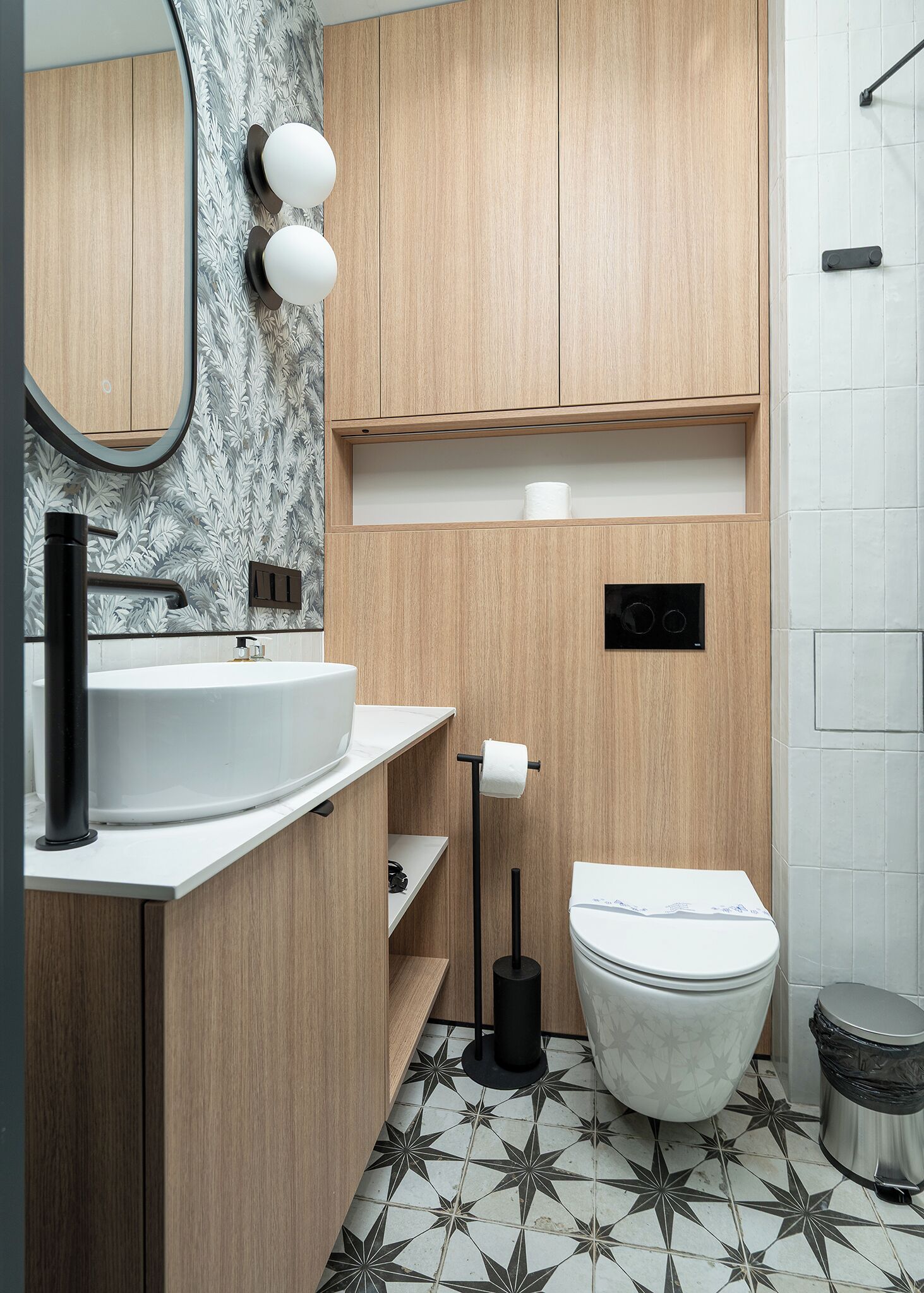 A modern bathroom with a wooden vanity, a sink, a toilet, and a shower area.