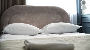 A bed with a headboard, two pillows, and a folded blanket. - RentPlanet - Apartament Wałowa (Warsaw)