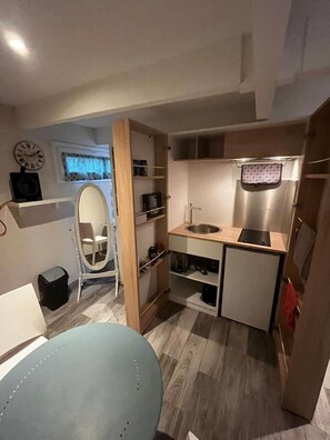 A compact kitchenette with a sink, microwave, and storage shelves. - Comfortable studio with private terrace and pool access (Portes-lès-Valence)