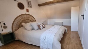 Une chambre à coucher comprenant un lit, une table de chevet, une lampe et un radiateur fixé au mur.