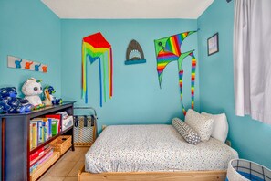 Ein Kinderzimmer mit Bett, Bücherregal und Wanddekorationen.