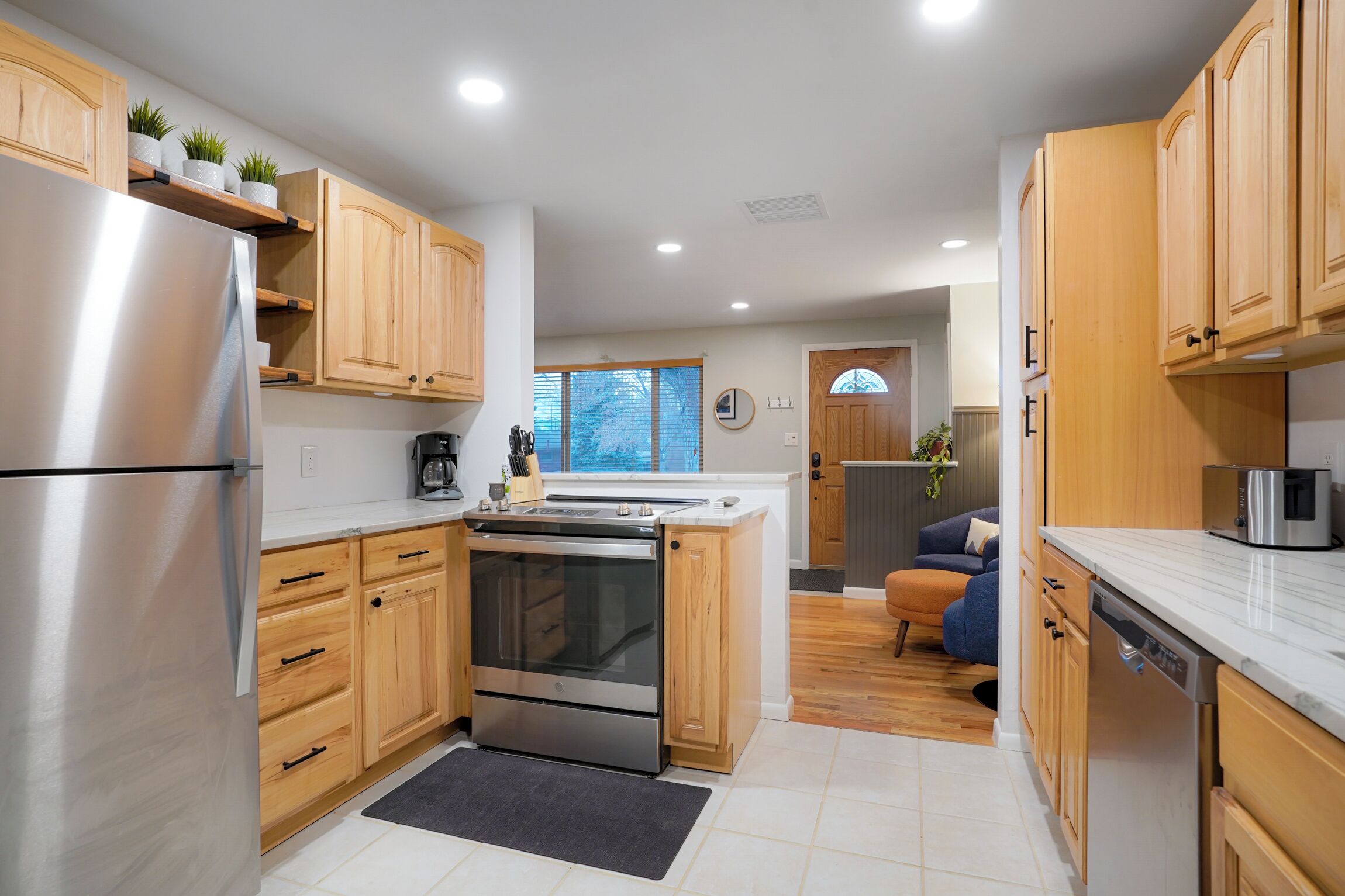 A modern kitchen with wooden cabinets, stainless steel appliances, and a built-in oven.