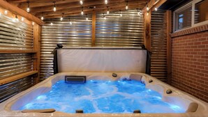A hot tub with a wooden ceiling and metal walls, surrounded by string lights. - Central Gem ~ Backyard Oasis with Hot Tub and Firepit (Arvada)