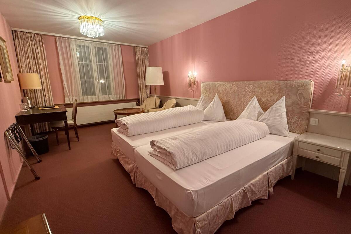 Una habitación de hotel con una cama grande, un escritorio y una silla.