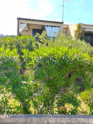 A building with a tiled roof, a satellite dish, and a window with a curtain. - Holiday Home 'Orizzonte Infinito' with Sea View, Wi-Fi and Air Conditioning (Cannigione)