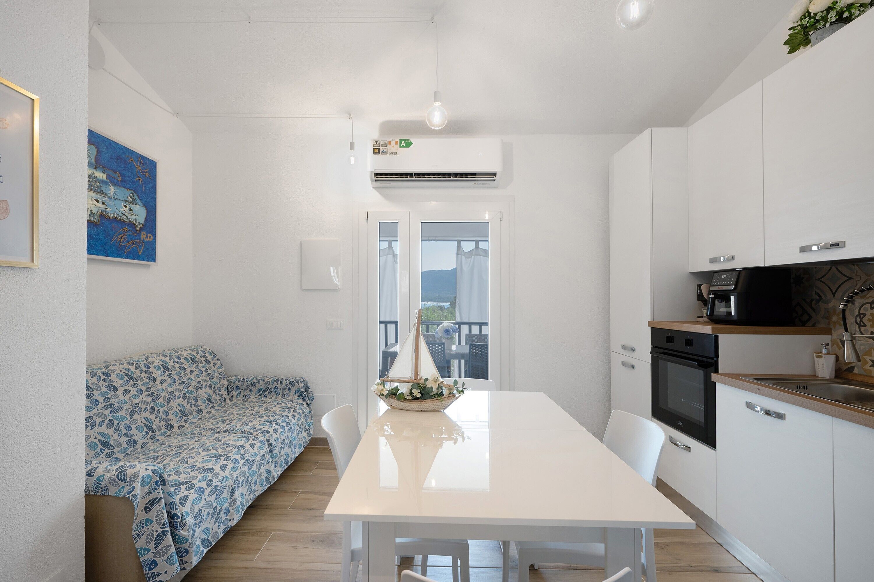 A compact kitchen with a dining table, white cabinets, and a built-in oven.