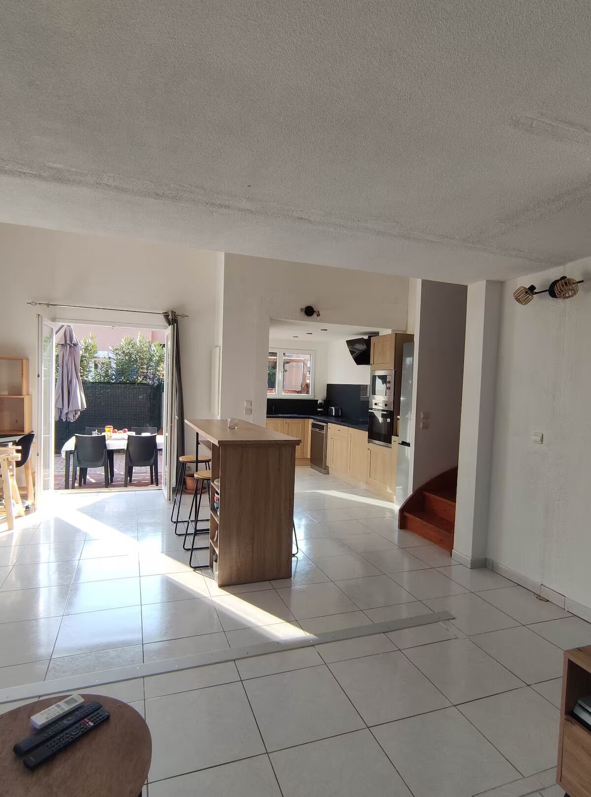 A spacious living area with a kitchen, dining area, and a view of the outside.