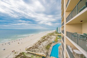 Ett hotell vid stranden med pool, utsikt över stranden och flera balkonger.