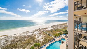 A beachfront hotel with a pool, a beach, and a clear sky. - Phoenix East 1011 3 Bedroom Condo (Orange Beach)