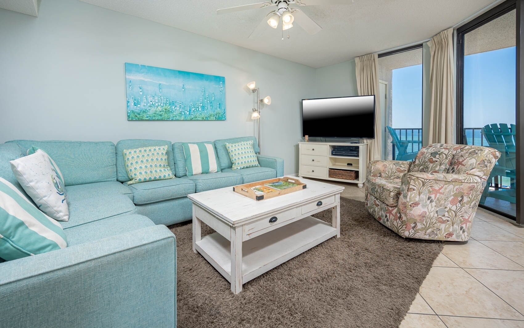 A living room with a sofa, a coffee table, a TV, and a chair.