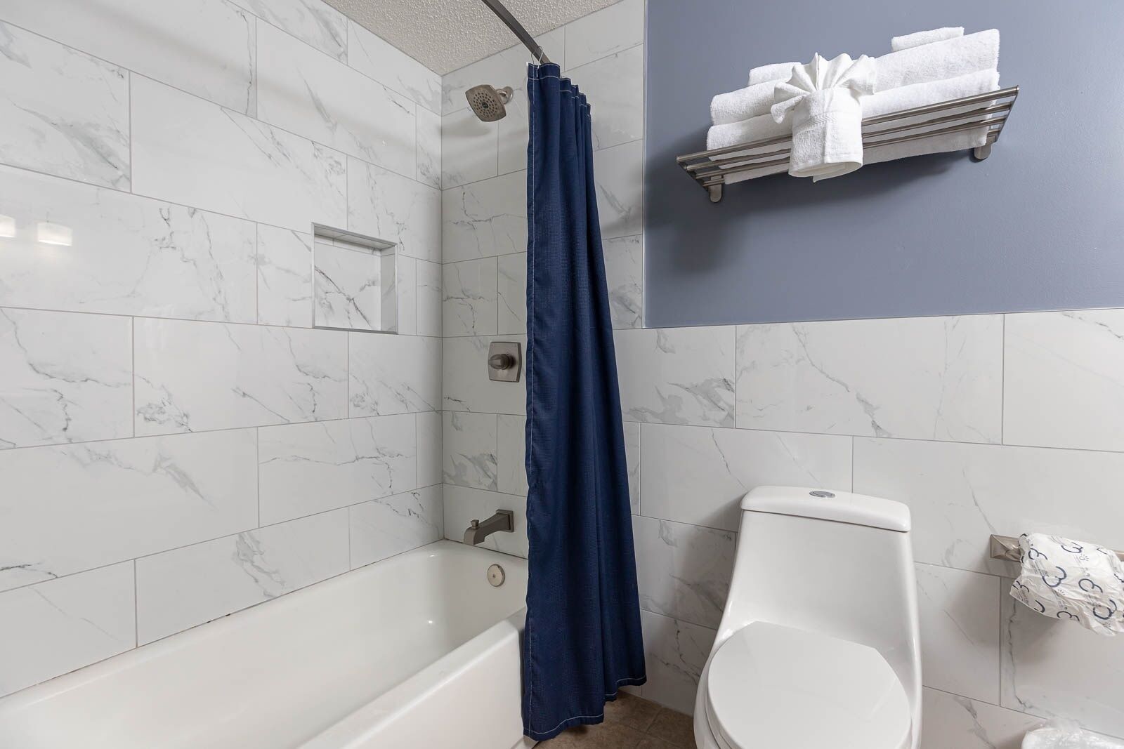 Une salle de bain équipée d’une douche, de toilettes et d’un porte-serviettes avec des serviettes.