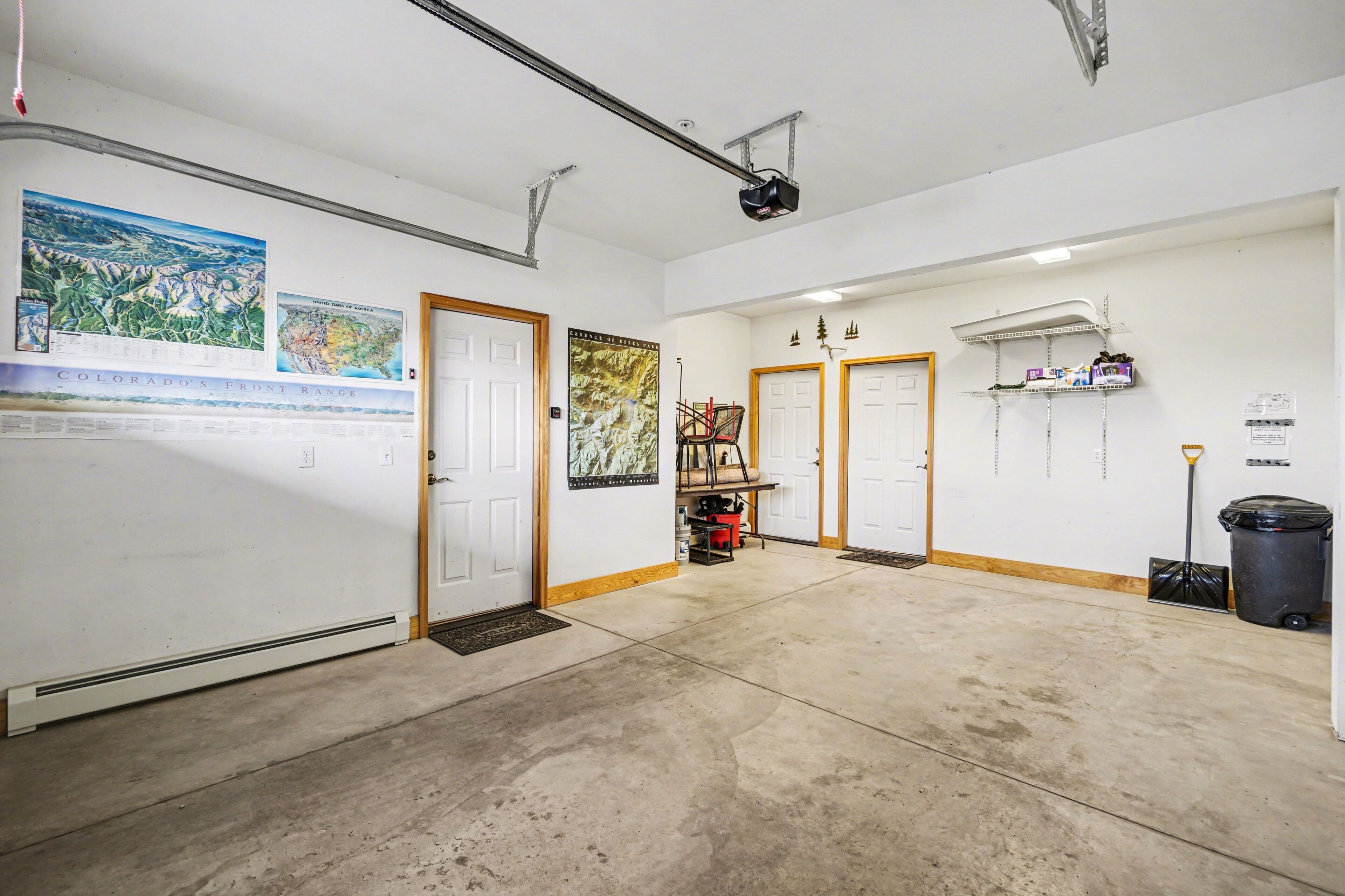 A spacious hallway with white walls, a projector, and a map of Colorado's Front Range.