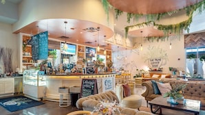 A coffee shop interior with seating, a counter, and a chalkboard menu. - Gulfview Retreat At The Palms 2 Bedroom Condo (Destin)