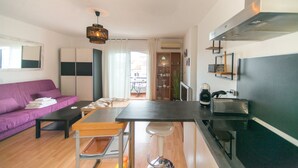A compact living space with a kitchenette, a dining area, a sofa, and a view of the outdoors. - WELCS STUDIO 301 EMP with view of the canal (Empuriabrava)
