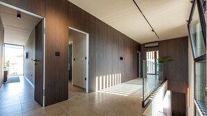 A modern interior with a wooden wall, a glass railing, and a staircase. - Villa Carrara ZadarVillas (Pakoštane)