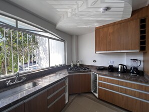 Una cocina moderna con un ventanal grande, armarios de madera y lavavajillas integrado.